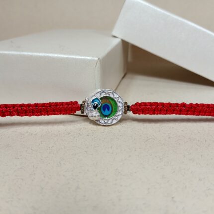 Silver Peacock Feather Rakhi with Red Thread