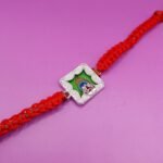 Silver Peacock Feather & Trishul Rakhi with Red Thread
