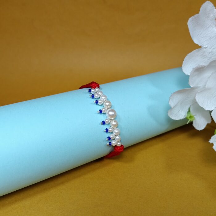 Elegant Pearl Beaded Rakhi with Blue Drops on Red Thread