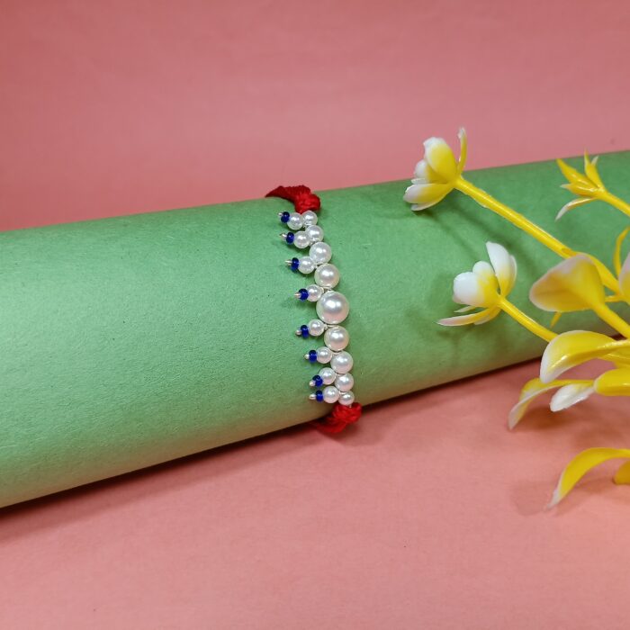 Elegant Pearl Beaded Rakhi with Blue Drops on Red Thread