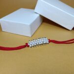 Radiant Pearl Rakhi: Graceful Bonds of Siblings