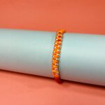 Surya Sutra Rakhi – Handwoven Orange Thread Rakhi with 925 Silver Beads