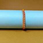 Surya Sutra Rakhi – Handwoven Orange Thread Rakhi with 925 Silver Beads