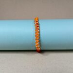 Surya Sutra Rakhi – Handwoven Orange Thread Rakhi with 925 Silver Beads