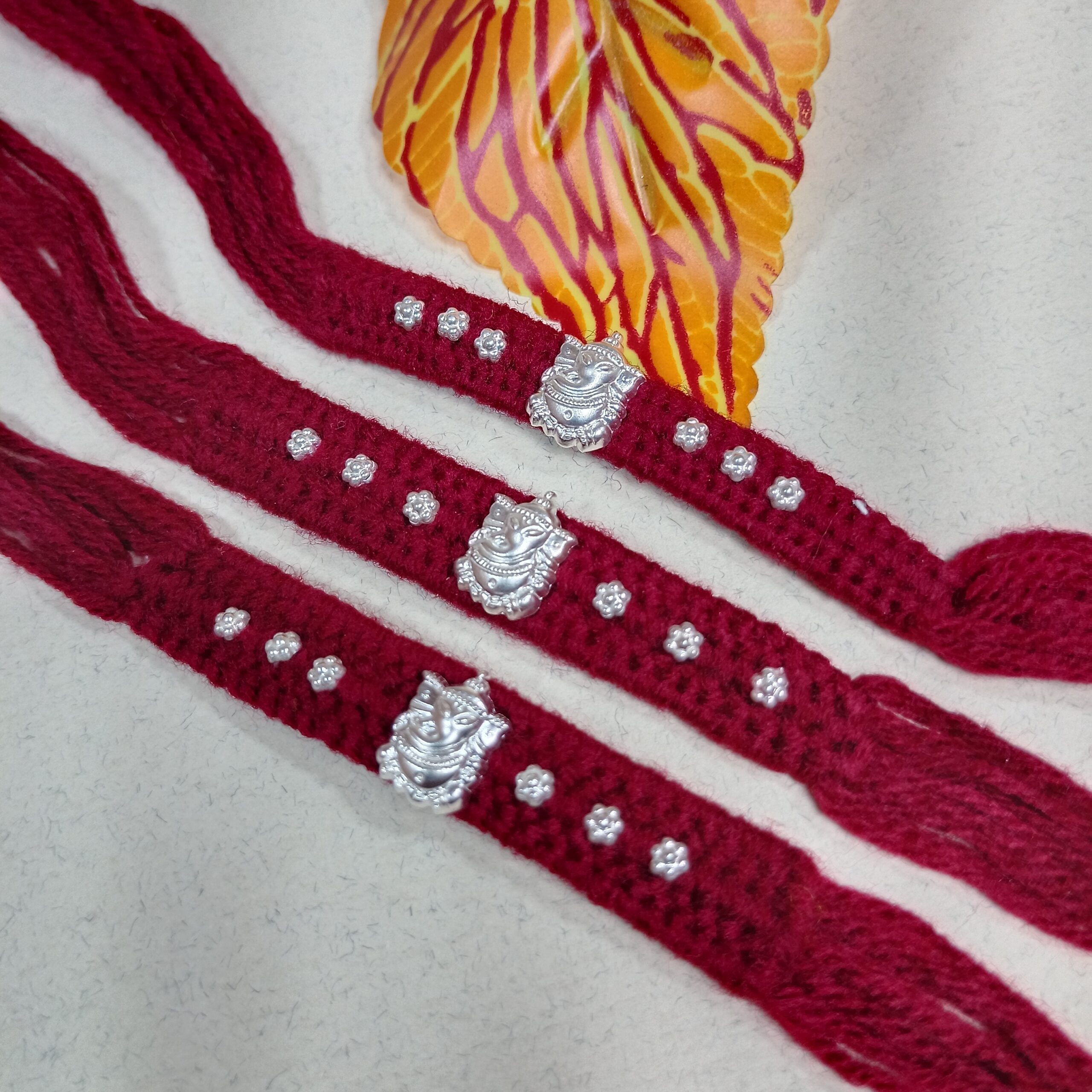 IMG_20250724_185425 Pure Silver Ganesha Rakhi – Sacred Protection Thread in Maroon (3 pieces )